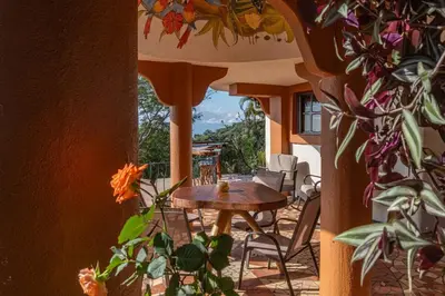 a table and chairs on a patio with a view at Casa Nubes - Ocean View in Carrillo