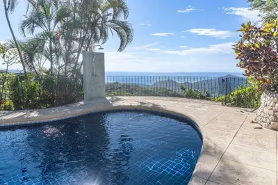 a swimming pool with a view of the ocean at Casa Nubes - Ocean View in Carrillo