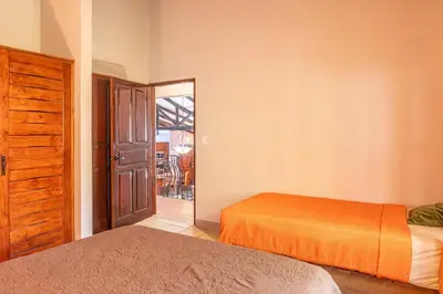 a bedroom with two beds and an open door at Casa Nubes - Ocean View in Carrillo
