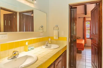 a bathroom with two sinks and a mirror at Casa Nubes - Ocean View in Carrillo