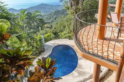 a blue swimming pool sitting on top of a house at Casa Nubes - Ocean View in Carrillo