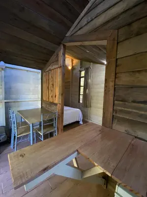 a dining room with a table and a bed at Pipe's Cabin in San Pablo
