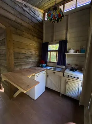 a kitchen with a stove and a table in a room at Pipe's Cabin in San Pablo