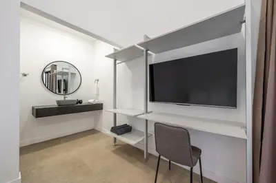 a living room with a large television and a chair at Pinilla Living Studio 2 in Santa Cruz