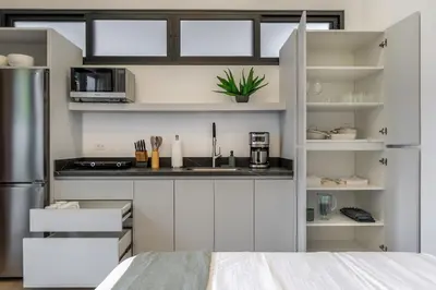a kitchen with white cabinets and a counter top at Pinilla Living Studio 2 in Santa Cruz