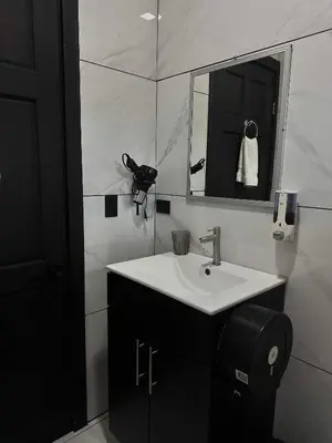 a white bathroom with a sink and a mirror at Cozy Studio with private tropical forest in Tanque