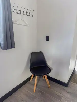 a black chair sitting in a corner next to a wall at Cozy Studio with private tropical forest in Tanque