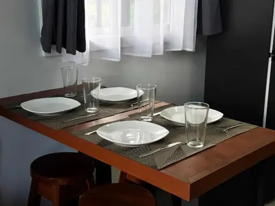 a wooden table with plates and glasses on it at Cozy Studio with private tropical forest in Tanque