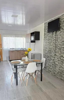 a dining room with a table and chairs and a kitchen at Casa las Nubes 5 minutes from the beach in La Cruz