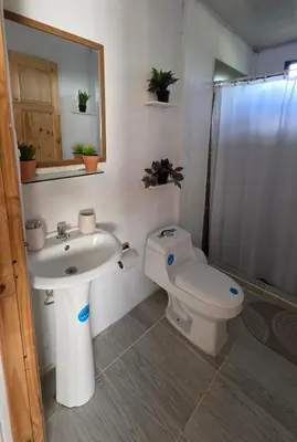 a bathroom with a sink and a toilet and a mirror at Casa las Nubes 5 minutes from the beach in La Cruz