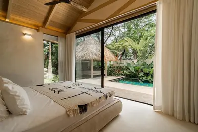 a bedroom with a bed and a large window at GoldCoast Villa Santa Teresa in Santa Teresa Beach