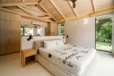 a bedroom with a large bed and a large window at GoldCoast Villa Santa Teresa in Santa Teresa Beach