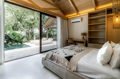 a bedroom with a large bed and a large window at GoldCoast Villa Santa Teresa in Santa Teresa Beach