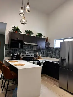 a kitchen with black cabinets and a white counter top at Secure Retreat Near SJO and 27, Ideal for Families in Nuestro Amo