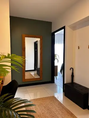 a living room with a mirror on a green wall at Secure Retreat Near SJO and 27, Ideal for Families in Nuestro Amo