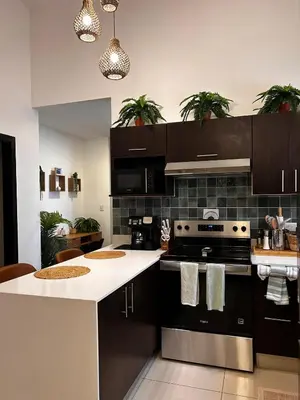 a kitchen with black cabinets and white counter tops at Secure Retreat Near SJO and 27, Ideal for Families in Nuestro Amo
