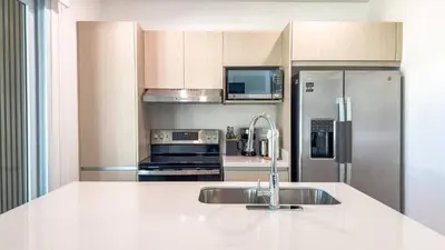 a kitchen with a sink and a stainless steel refrigerator at New 4BDR Ocean Mountain View Villa - Mar a Mar in Punta Leona