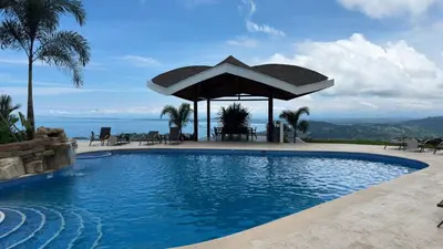 a swimming pool with a gazebo next to the ocean at New 4BDR Ocean Mountain View Villa - Mar a Mar in Punta Leona