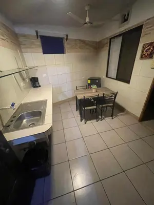 a kitchen with a sink and a table with chairs at Apartamento Melida 3 in Quepos