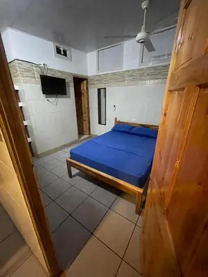 a bedroom with a blue bed and a tv at Apartamento Melida 3 in Quepos