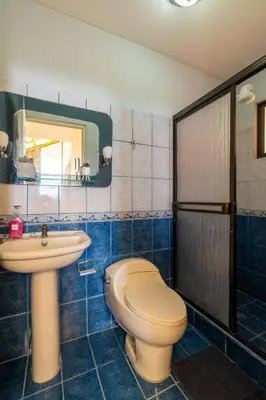 a bathroom with a toilet and a sink at Villa Familiar 3BR Vistas al Valle & Naturaleza in Turrialba