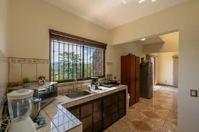 a large kitchen with a sink and a window at Villa Familiar 3BR Vistas al Valle & Naturaleza in Turrialba