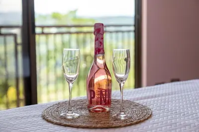 a bottle of wine sitting between two glasses on a table at Villa Familiar 3BR Vistas al Valle & Naturaleza in Turrialba