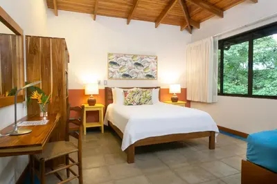 a bedroom with a bed and a desk and a bed sidx sidx sidx at Olas Verdes Hotel in Nosara