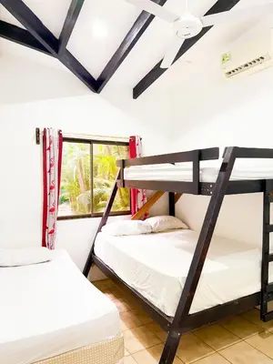 two bunk beds in a room with a window at Selva Partners Tamarindo in Matapalo