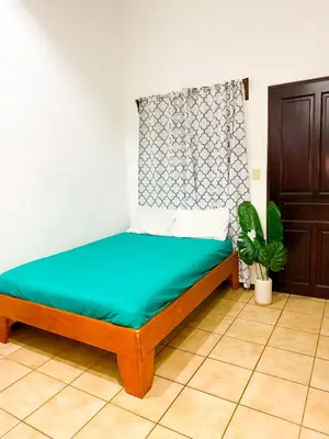 a bedroom with a bed with a green mattress at Selva Partners Tamarindo in Matapalo