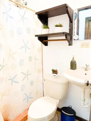 a bathroom with a toilet and a sink at Selva Partners Tamarindo in Matapalo