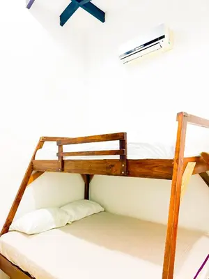 a bunk bed with a air conditioner on the wall at Selva Partners Tamarindo in Matapalo