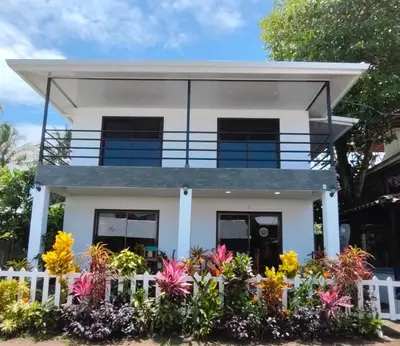 a house with flowers in front of it at Hospedaje Casa Blanca Tortuguero in Tortuguero