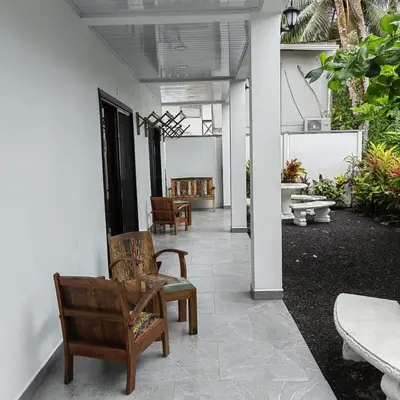 a hallway with chairs and tables in a building at Hospedaje Casa Blanca Tortuguero in Tortuguero