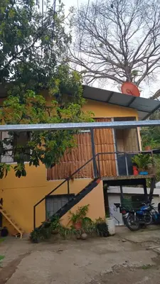 a yellow building with a staircase in front of it at Casa Jenny in Quepos