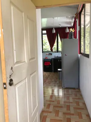 an open door to a kitchen with a refrigerator at Casa Jenny in Quepos