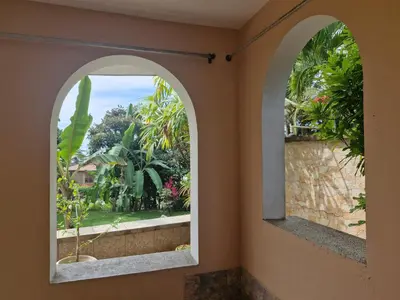 an arched window with a view of a garden at El Diamante - Playa Hermosa in Playa Hermosa
