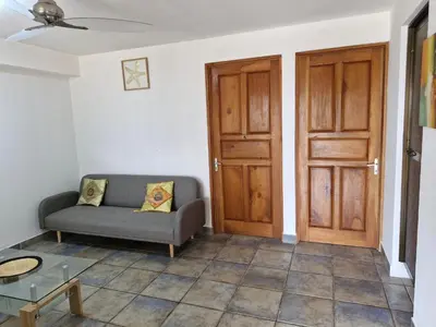 a living room with a couch and a wooden door at El Diamante - Playa Hermosa in Playa Hermosa