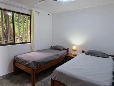 two beds in a room with a window at El Diamante - Playa Hermosa in Playa Hermosa
