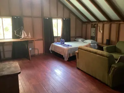 a room with a bed and a couch and windows at House on the Hill in Montezuma