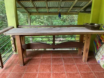 a wooden table with a bench on a porch at House on the Hill in Montezuma