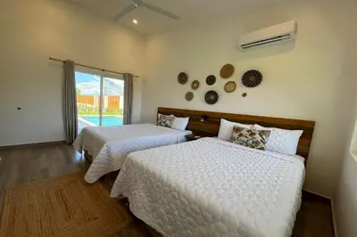 a bedroom with two beds and a window at Triskele Retreat - Combo Ocean and Earth in Esterillos