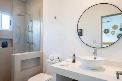 a white bathroom with a sink and a mirror at Triskele Retreat - Combo Ocean and Earth in Esterillos