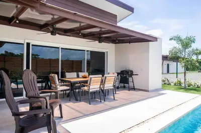 a patio with a table and chairs next to a pool at Triskele Retreat - Combo Ocean and Earth in Esterillos