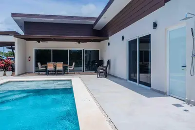 a house with a swimming pool and a patio at Triskele Retreat - Combo Ocean and Earth in Esterillos