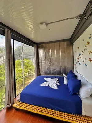 a large bed in a room with a window at Pupa House Hotel in Tamarindo