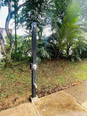 a black pole with wheels on the side of a sidewalk at Beach Apartment with Pool and Lake - Playa Hermosa in Playa Hermosa