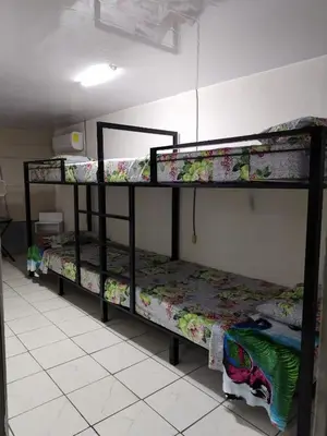 a room with three bunk beds in a room at Hostel La Bambú in Quepos