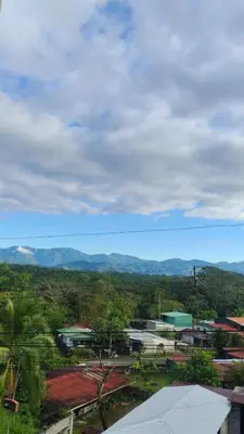 a view of a town with mountains in the background at Hostel La Bambú in Quepos