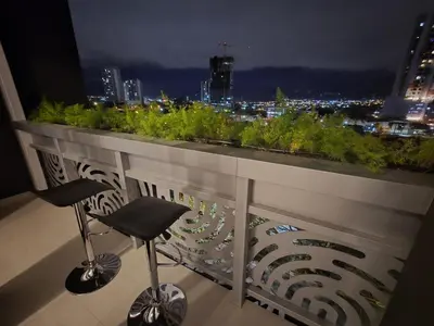 a balcony with a view of a city at night at Sky Escalante Apartment in San José